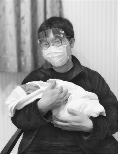 土元 哲平氏がコロナ禍の最中に生まれた娘を抱きかかえている様子の写真